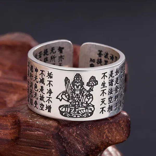 Bague bouddhiste vintage en cuivre, finement gravée d'une image de Bouddha guerrier, brillant sur fond de bois