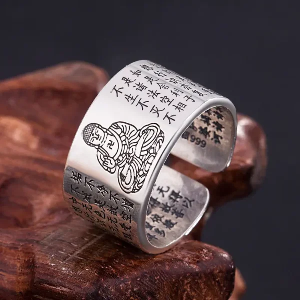 Bague bouddhiste vintage en cuivre, finement gravée d'une image de Bouddha, brillant sur fond de bois