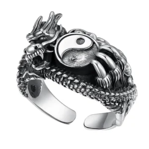 Cette image présente une Bague de Force du Dragon Yin Yang, un bijou riche en symbolisme. Au centre, le symbole Yin Yang, représentant l'équilibre et la dualité, est tenu fermement par les griffes d'un dragon. La créature, détaillée avec une précision artistique, est forgée en acier inoxydable avec une finition qui évoque l'aspect vintage. Le dragon semble serpenter autour du doigt, offrant un contraste frappant entre l'antique et le moderne. La bague semble robuste mais raffinée, idéale pour ceux qui cherchent à affirmer leur style avec un accessoire symbolique et puissant.