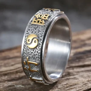 Une Bague de Protection et de Force Yin Yang, symbole de puissance et d'équilibre, repose élégamment sur un morceau de bois naturel. Une union parfaite entre la force intérieure et l'harmonie extérieure, capturée dans ce bijou unique