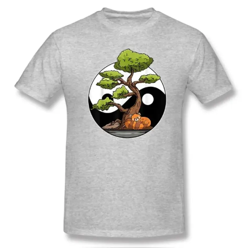 Un T-shirt de couleur grise affichant un design de Yin Yang au centre. Le Yin Yang est illustré par un paysage naturel où un côté est en lumière, avec un arbre à feuilles vertes et un animal paisible allongé en dessous, et l'autre côté est dans l'ombre, représentant l'équilibre harmonieux entre la tranquillité et la nature. Le T-shirt semble être fait de coton de haute qualité et est présenté sur un fond uni.